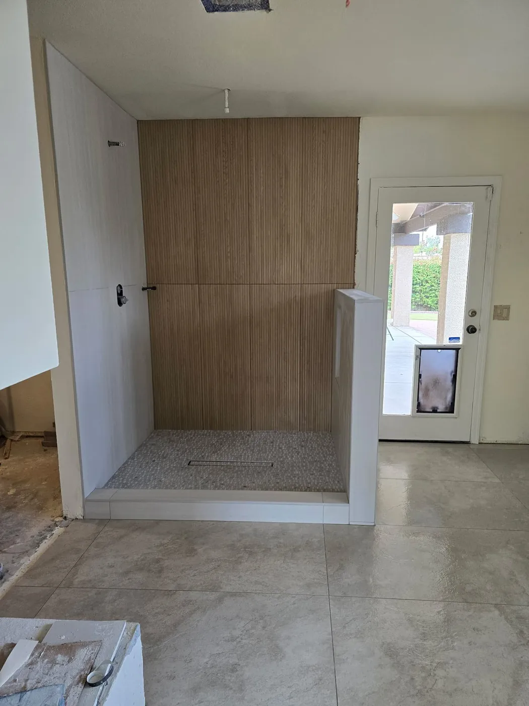 Walk-in shower with tile set and the floor still open