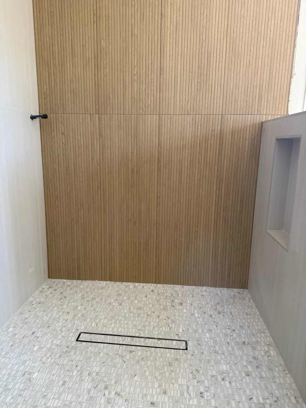 Walk-in shower with a recessed niche set into the tiled wall