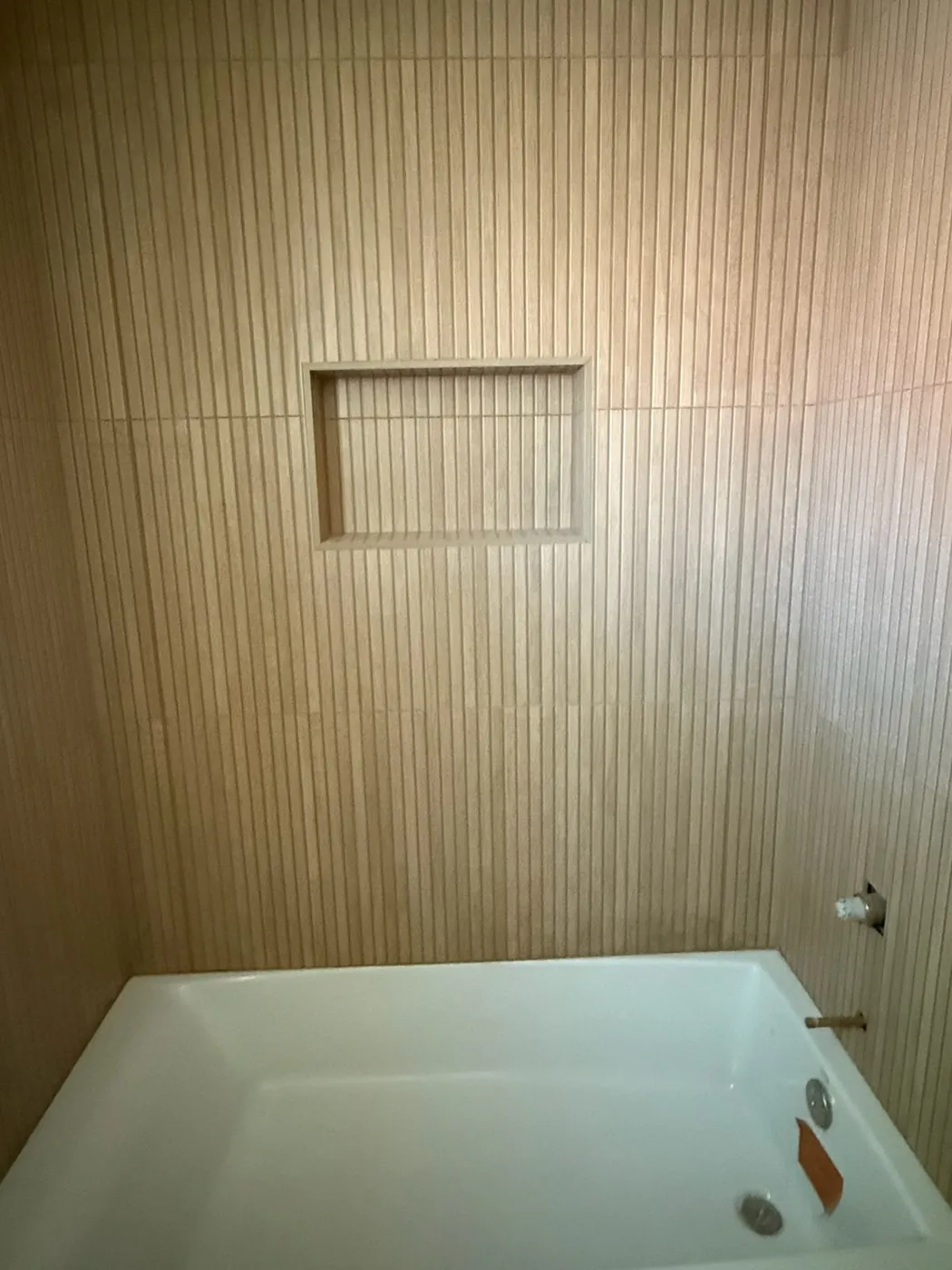 Alcove tub with a full-height tiled surround and recessed niche