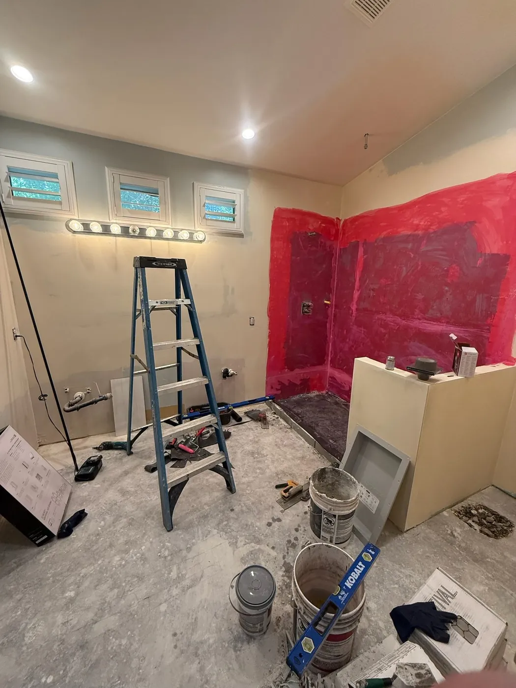 The same bathroom mid-build, with the shower waterproofed and the vanity wall open