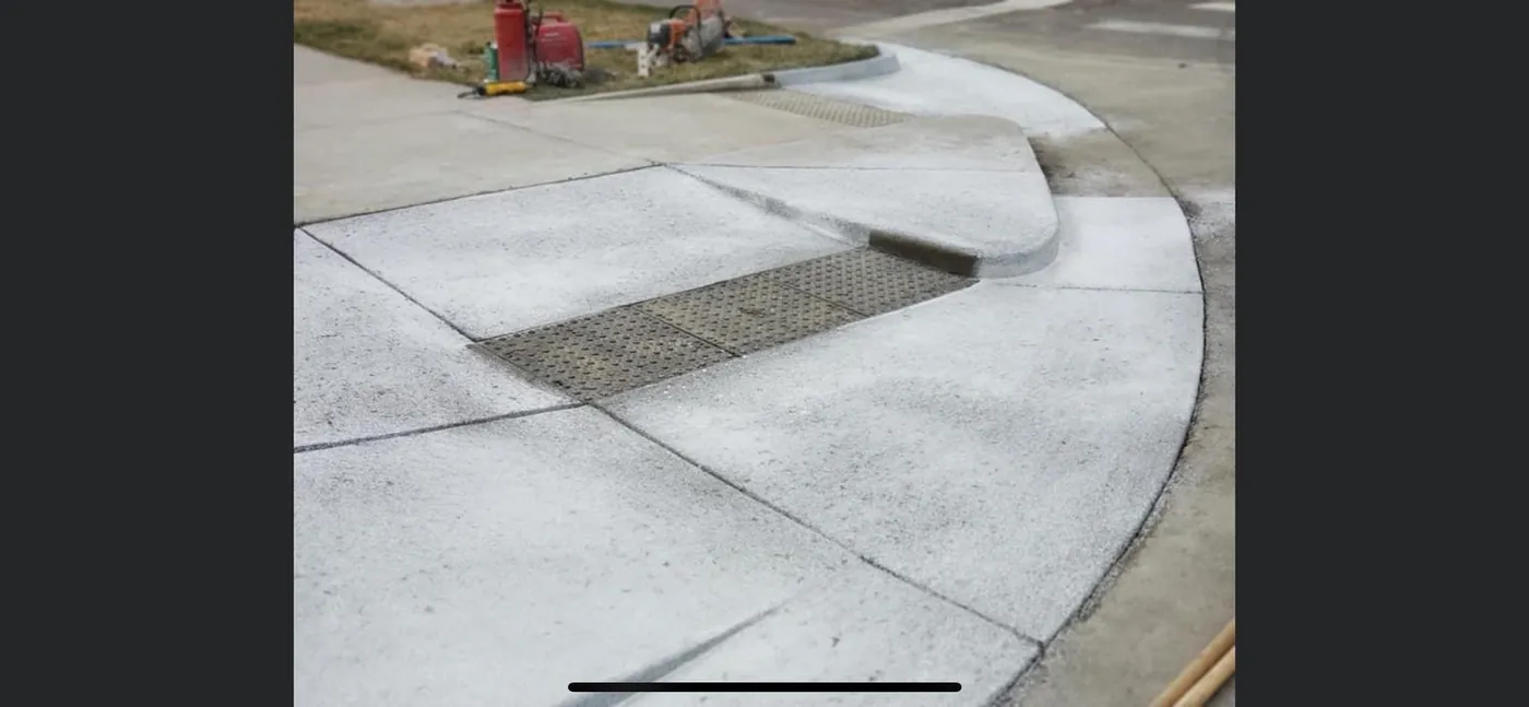 Curb ramp with a truncated-dome detectable warning panel set into the pour