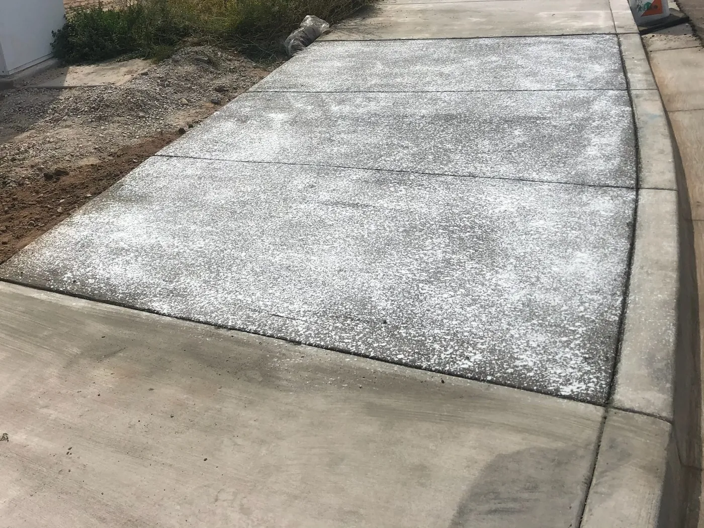 Finished broom-swept driveway apron tying into the existing curb
