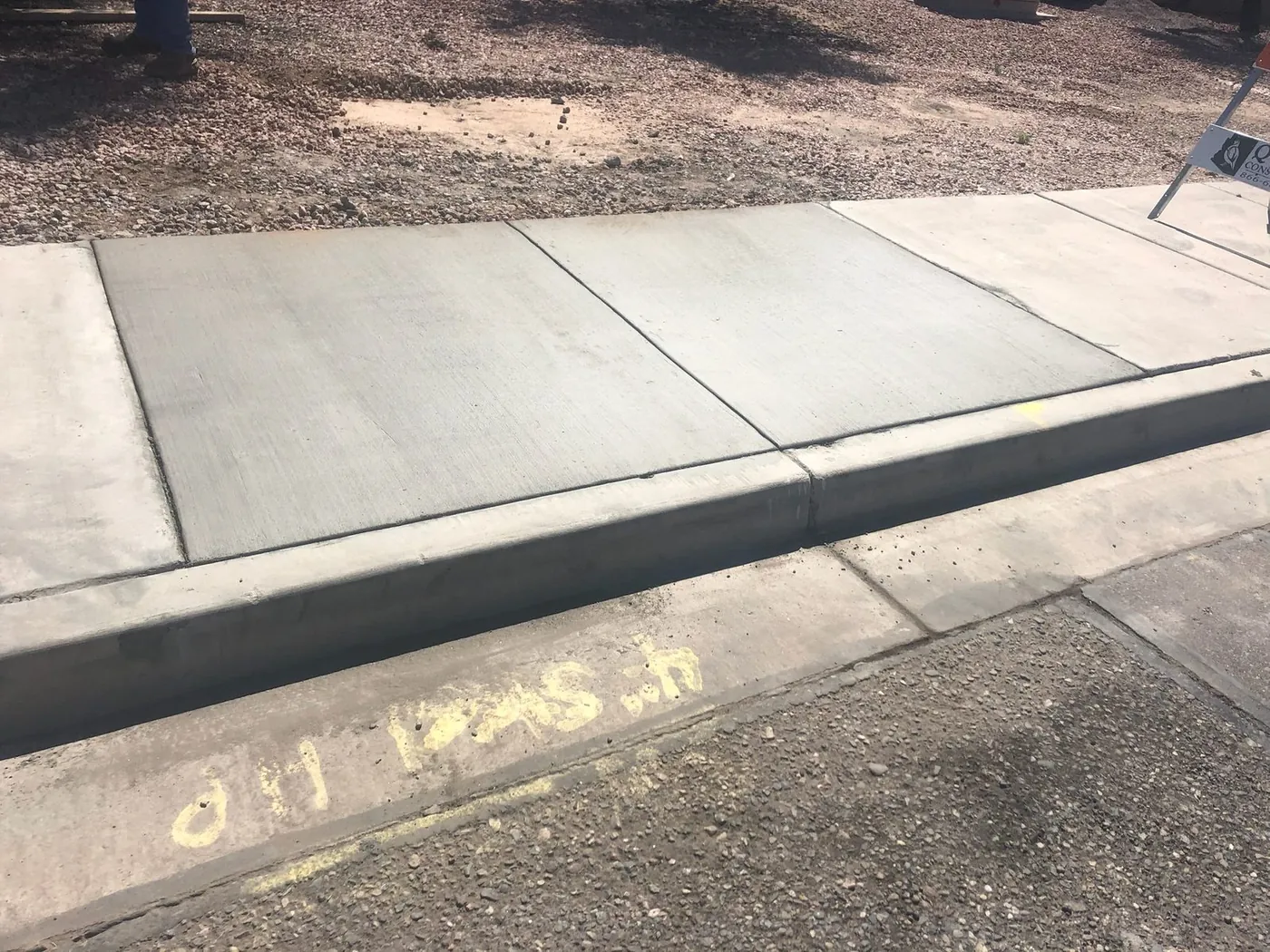 Newly poured sidewalk panels alongside the original curb line