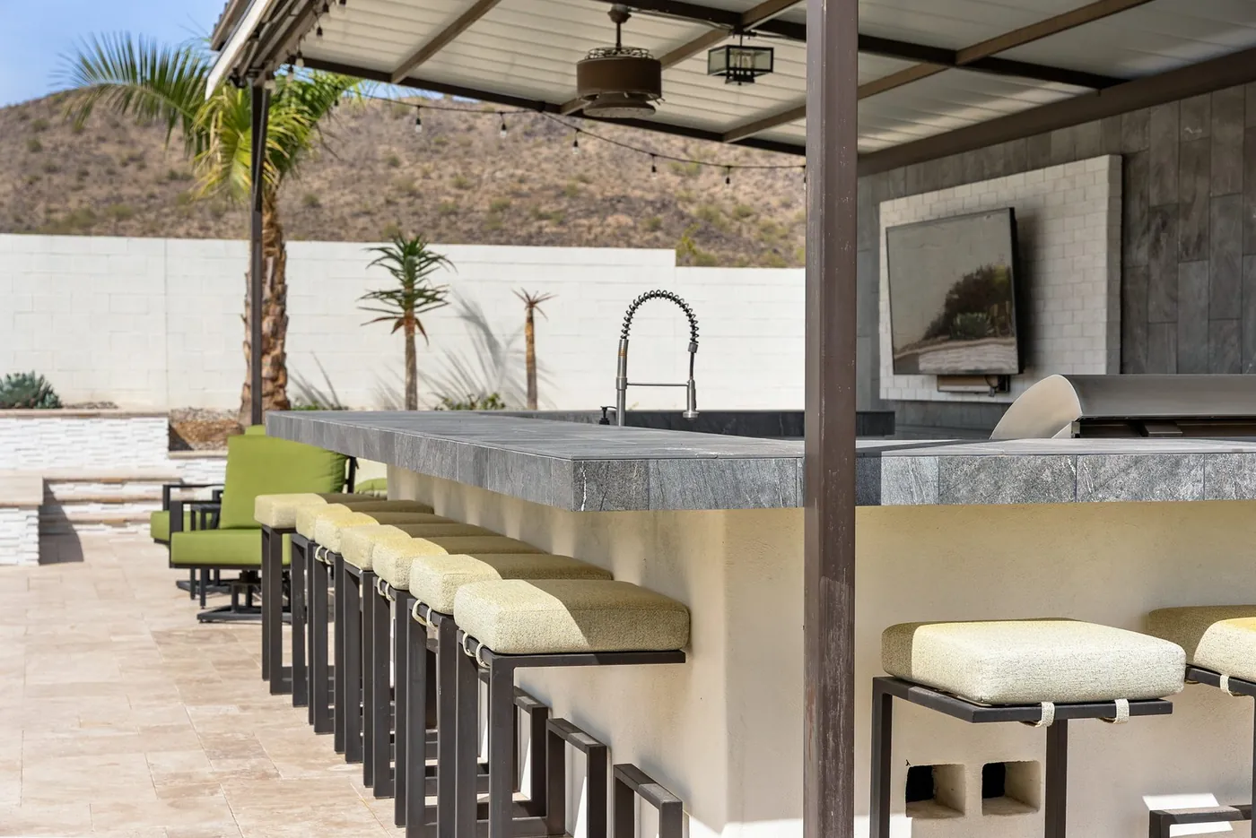 Outdoor bar counter, sink and stone-clad island under cover