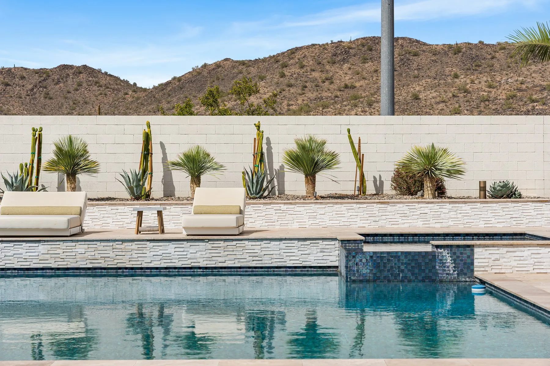 Pool with a tiled water feature wall and stacked-stone planter