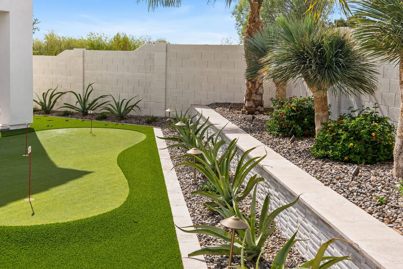 Putting green and planted border across the rear of the property