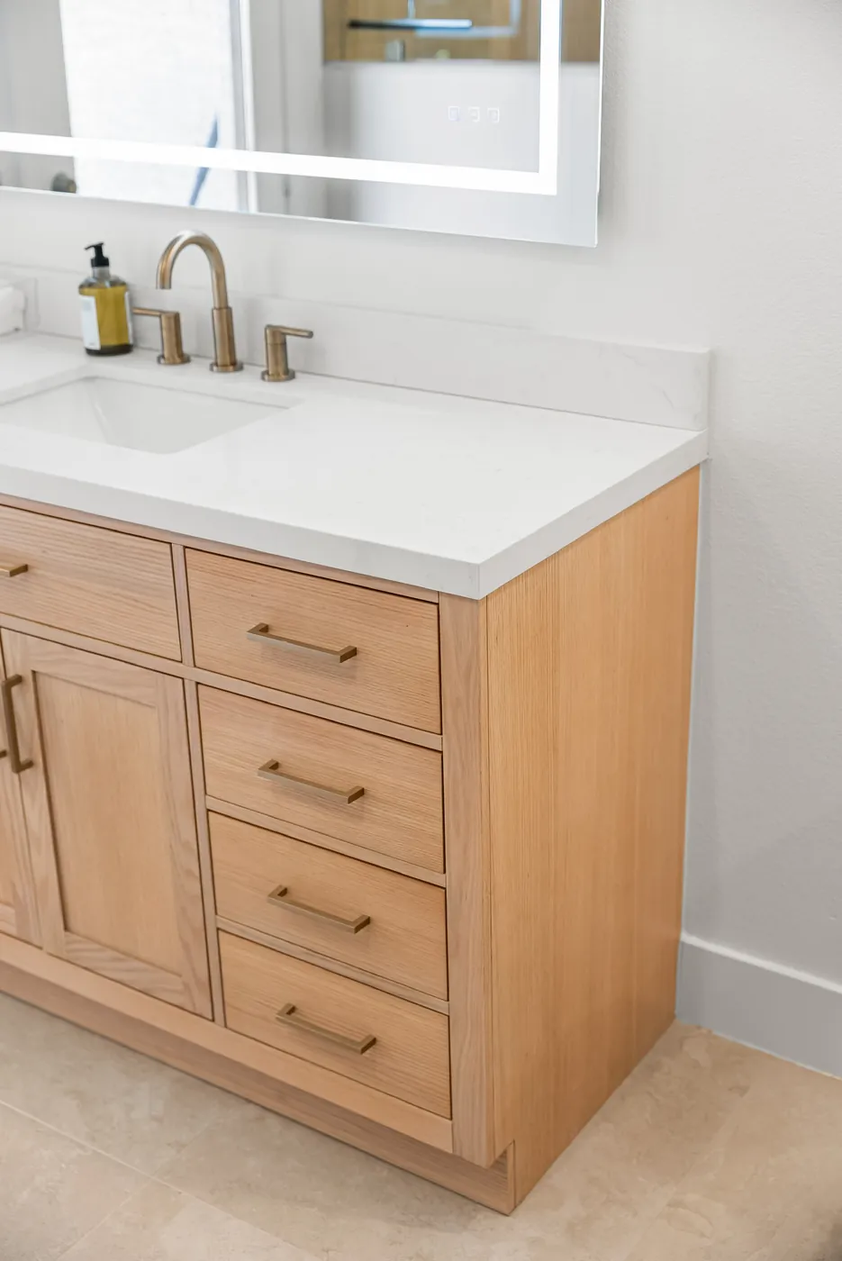 Vanity and lit mirror from the side, showing the drawer stack