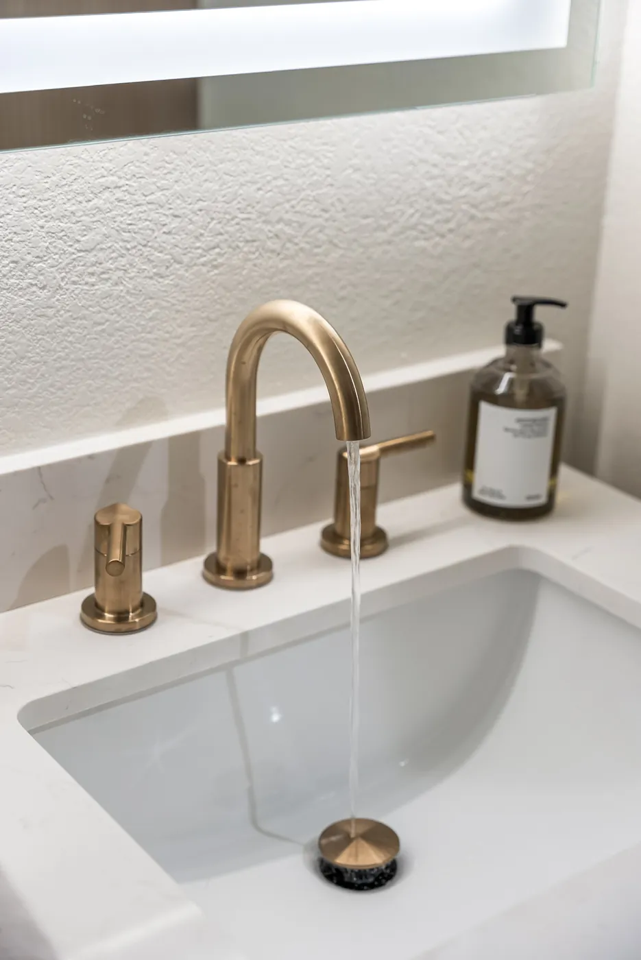 Water running from the brass faucet into the undermount sink