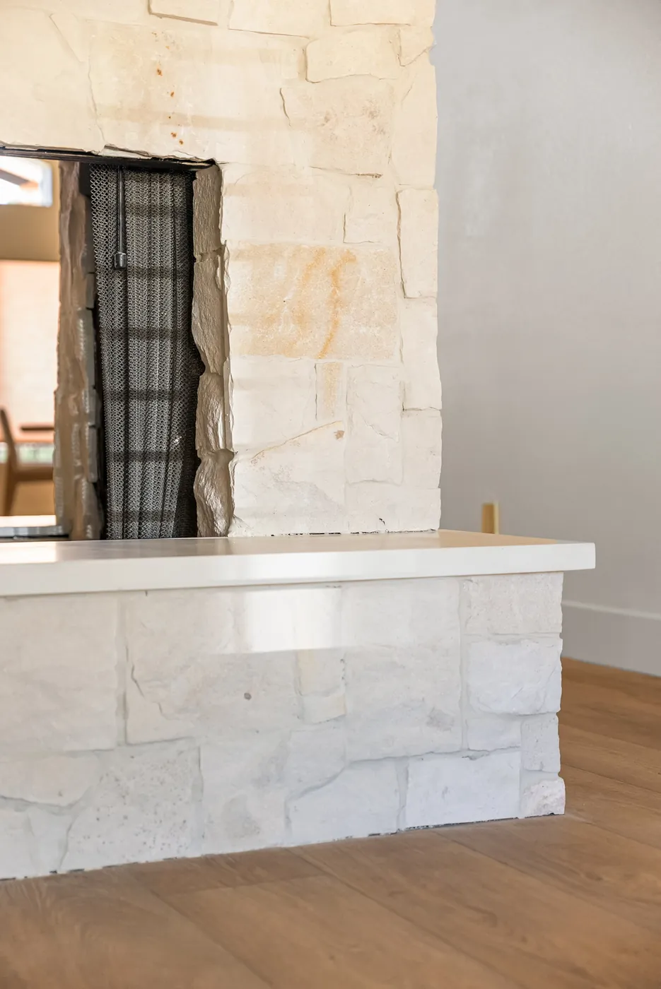 Fireplace refacing in progress: stacked stone and mantel set, firebox insert not yet installed