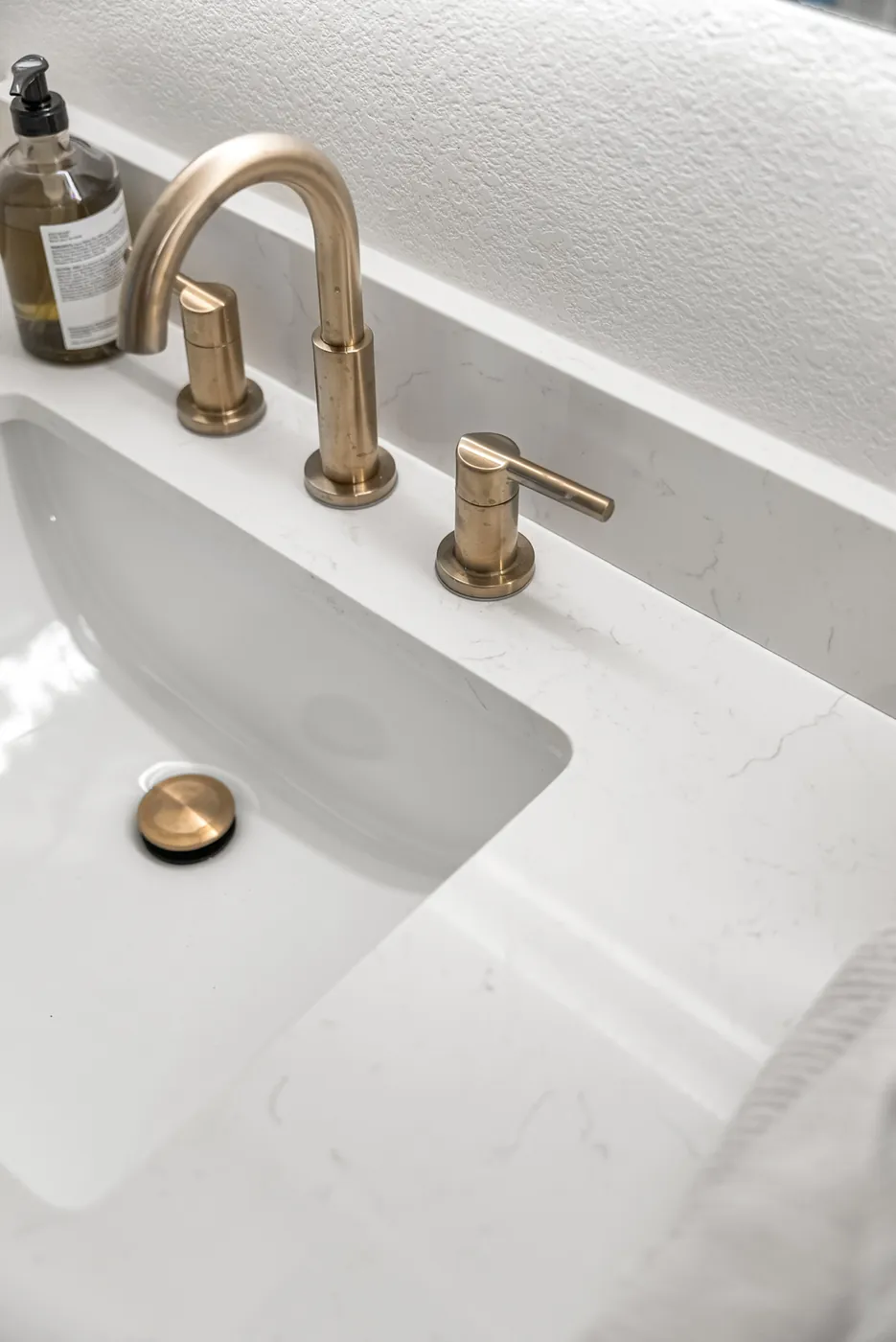 Widespread brass faucet on a white counter