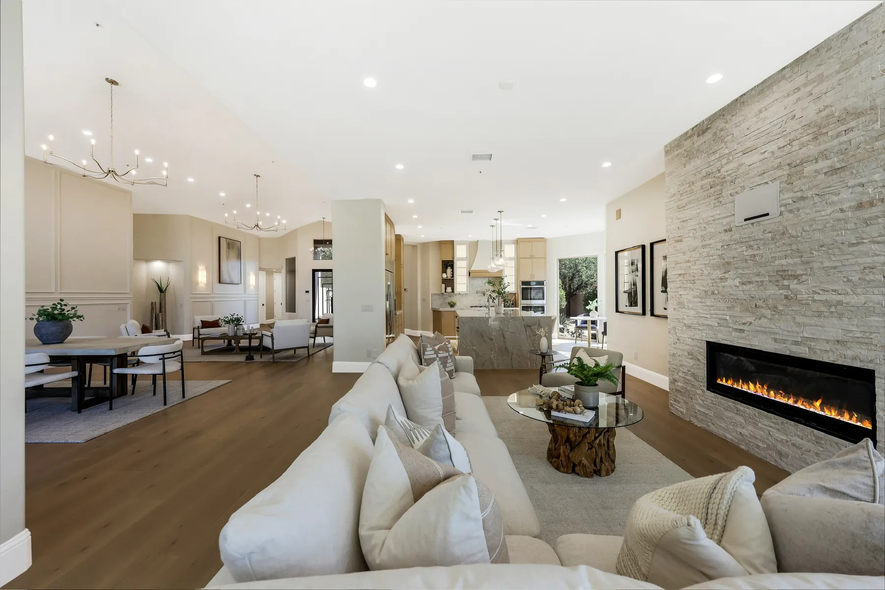 Completed Blackstone Contracting residence: great room with a stacked-stone linear fireplace and wide-plank flooring