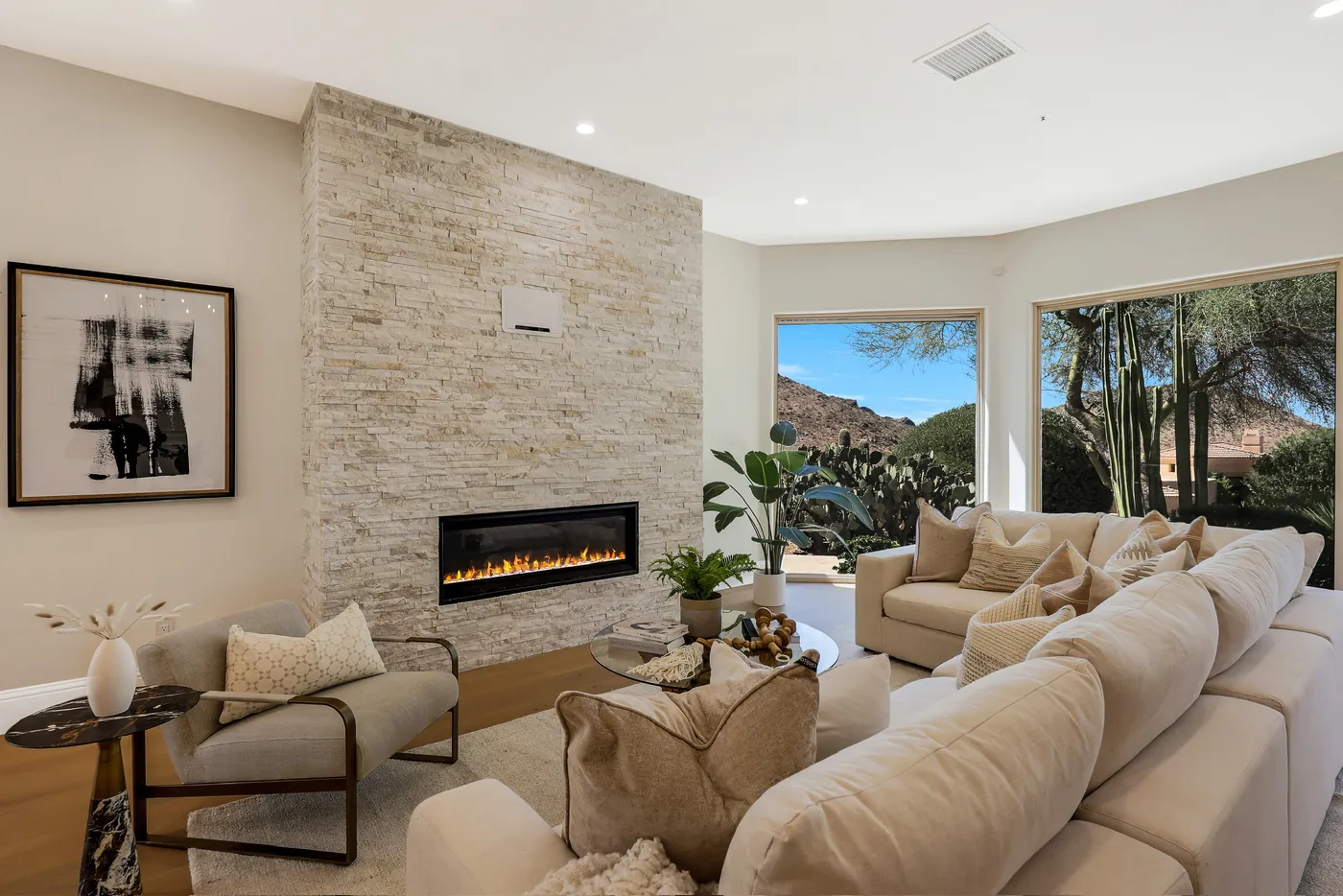 Linear fireplace set into a full-height stacked-stone wall beside the sectional