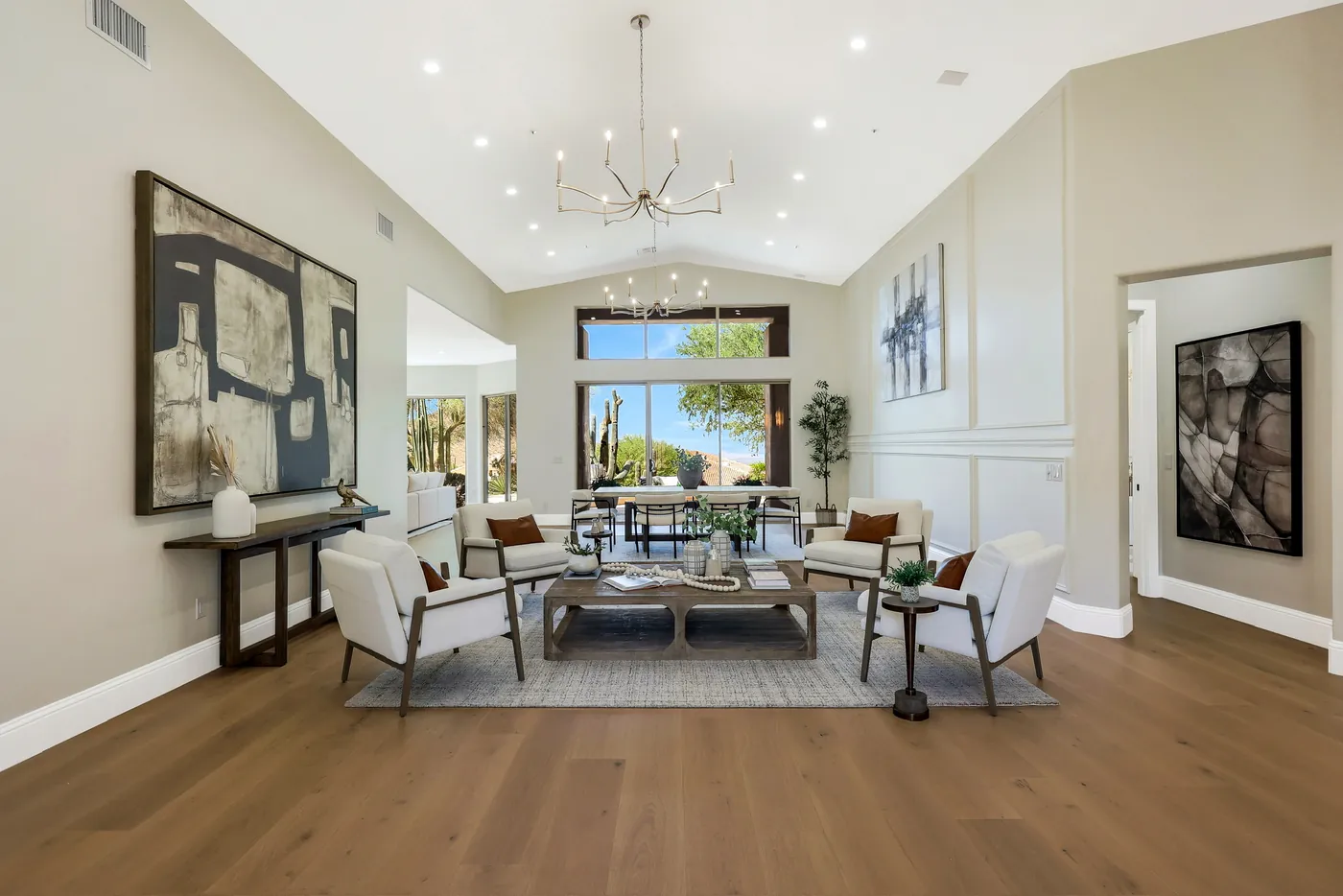 Living room from the entry, under a vaulted ceiling with a branched chandelier