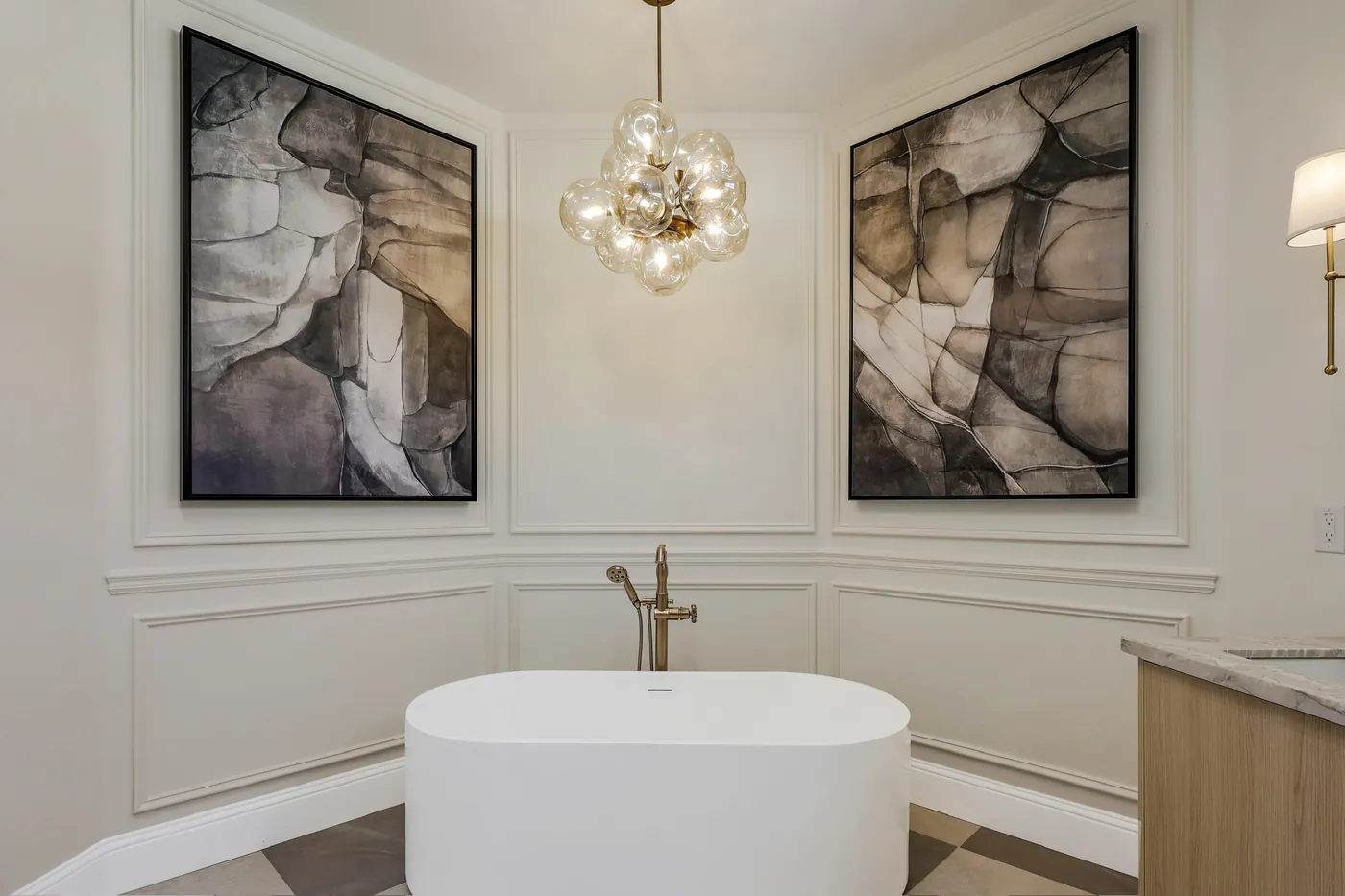 Tub set between panelled walls and two framed prints