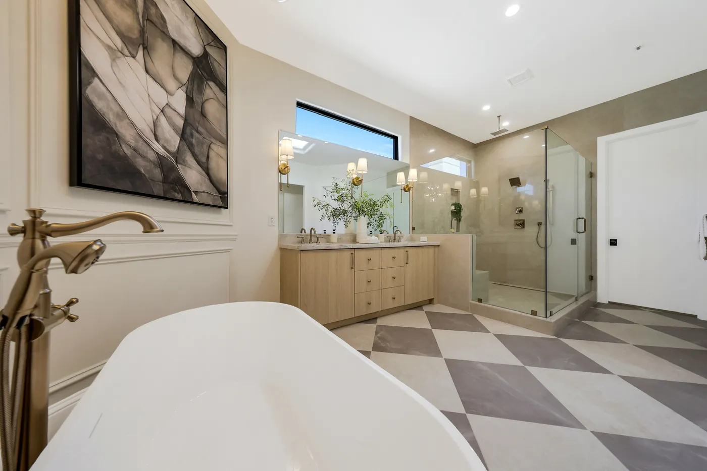 Tub with a floor-mounted filler, with the shower and vanity beyond