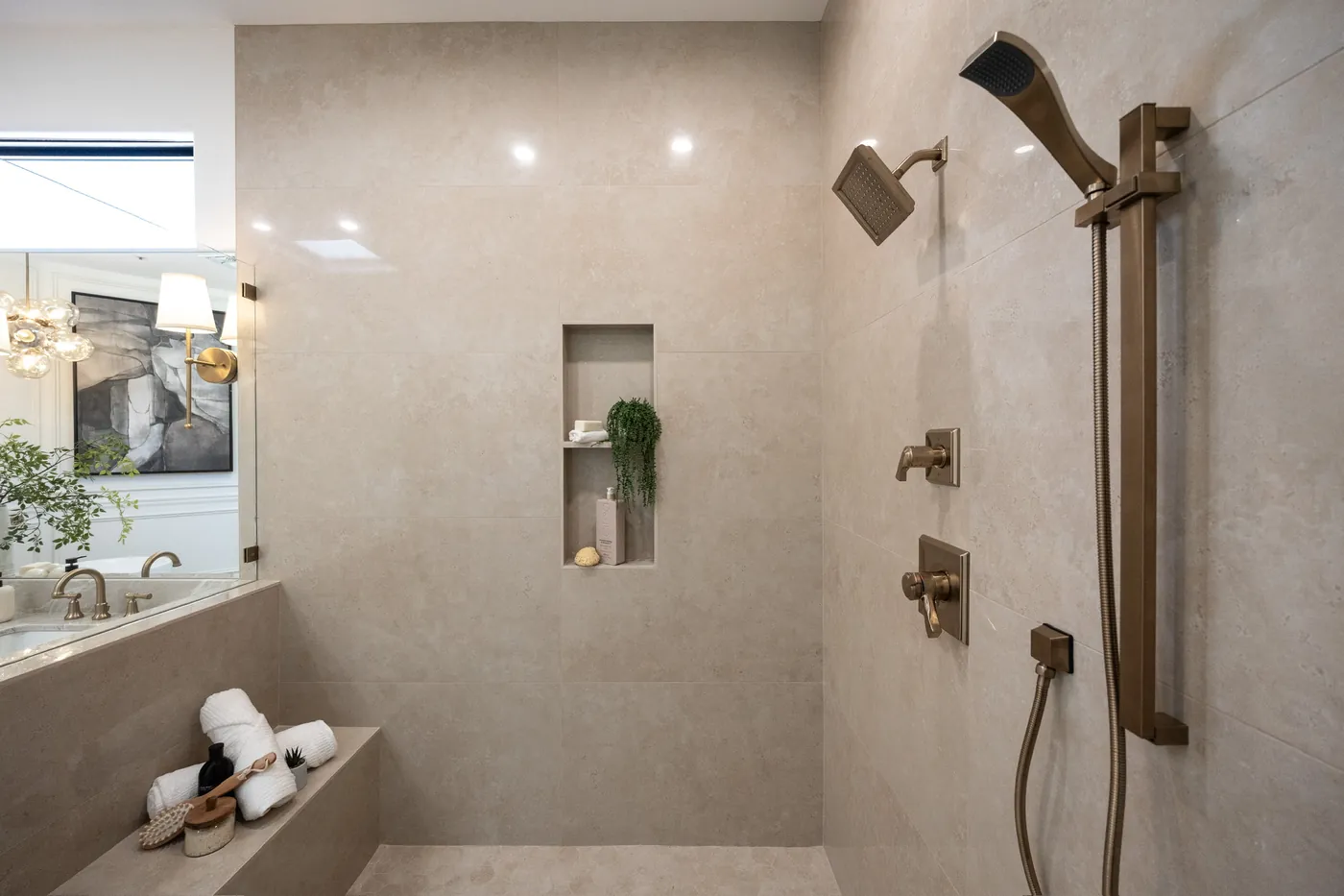 Walk-in shower with brushed-brass fixtures and a recessed niche