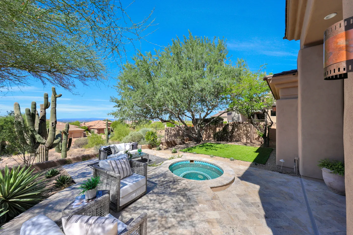 Spa and seating from the house, with the desert dropping away beyond the wall