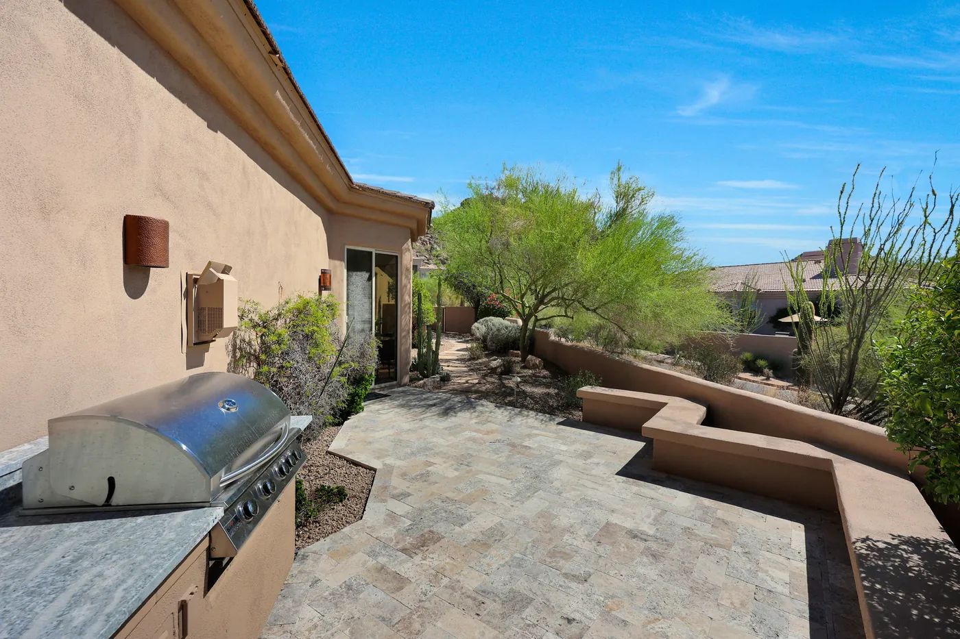 Built-in grill along the side terrace, with stepped stucco walls