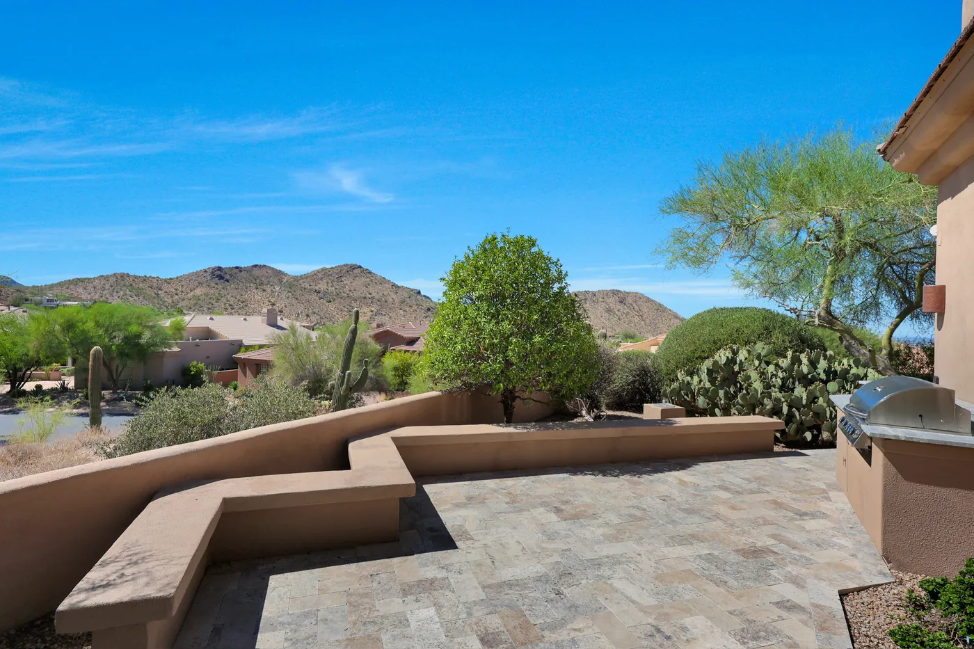 Stepped stucco walls and pavers looking out to the mountain ridge