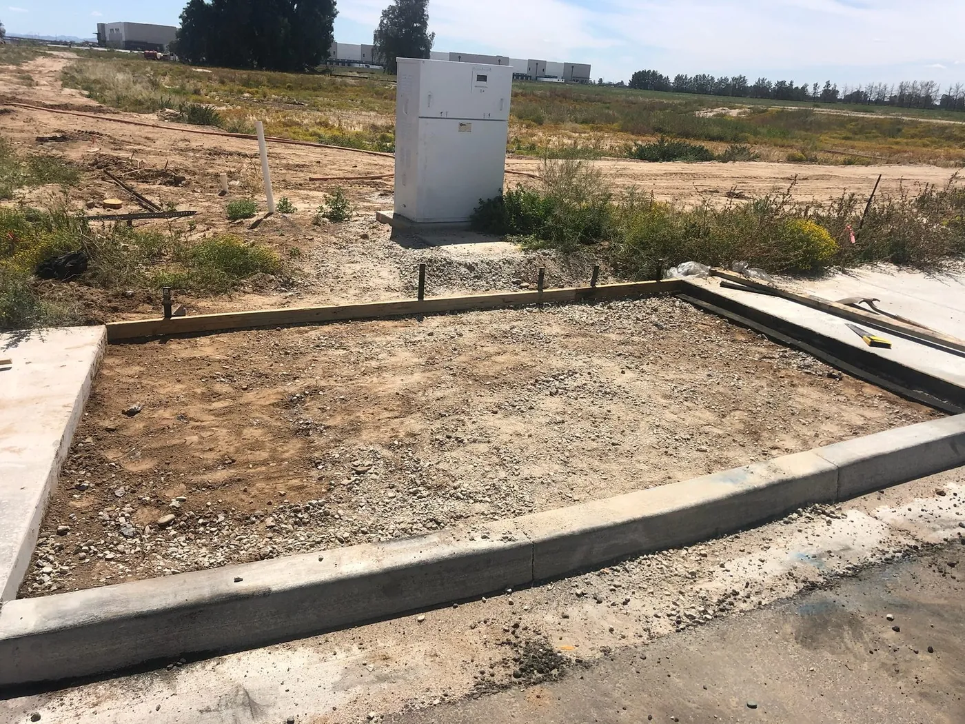 Curb and footing formed out across a cleared commercial lot